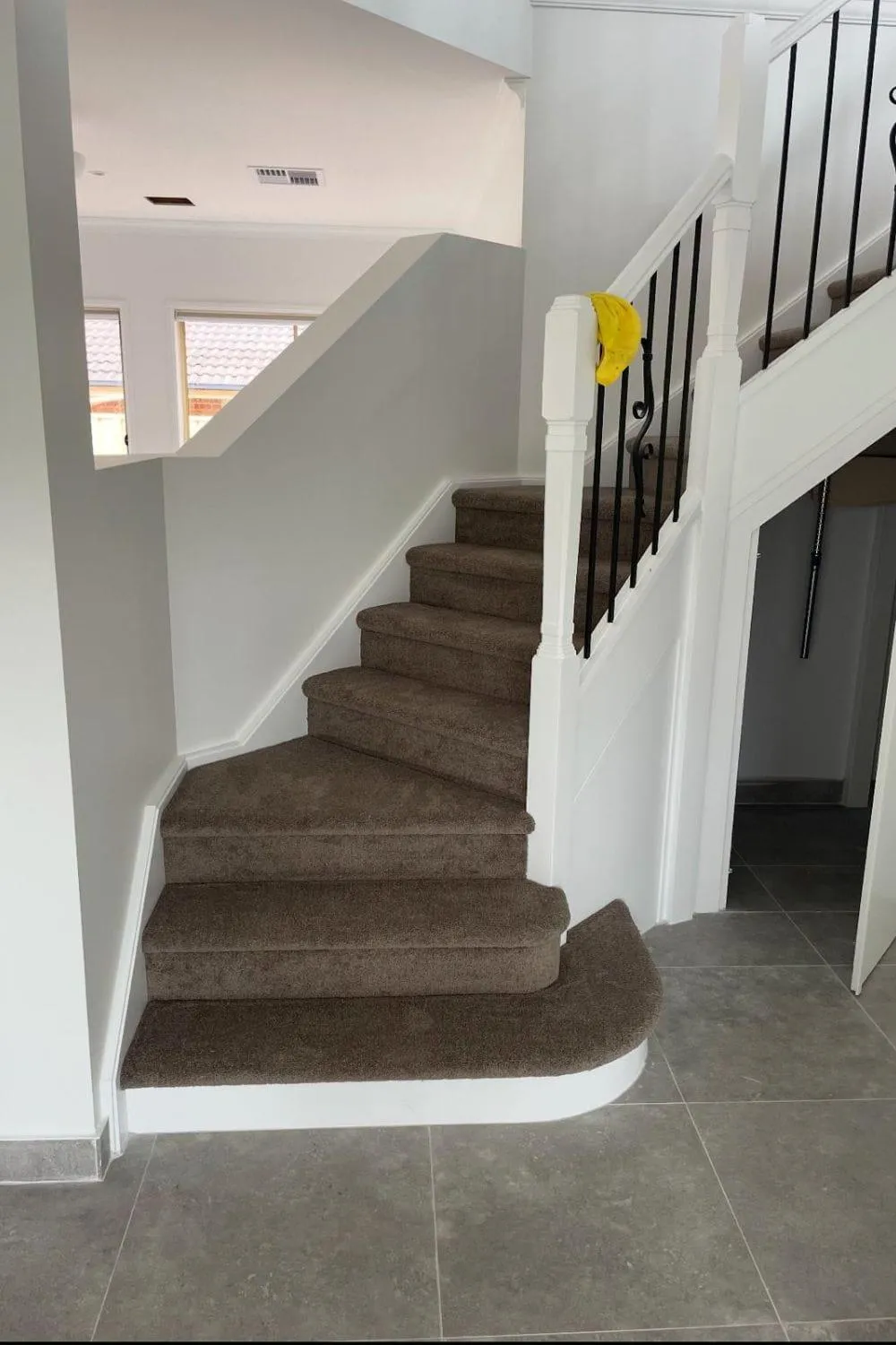 A finished charcoal carpet staircase laid by Brad's Carpets